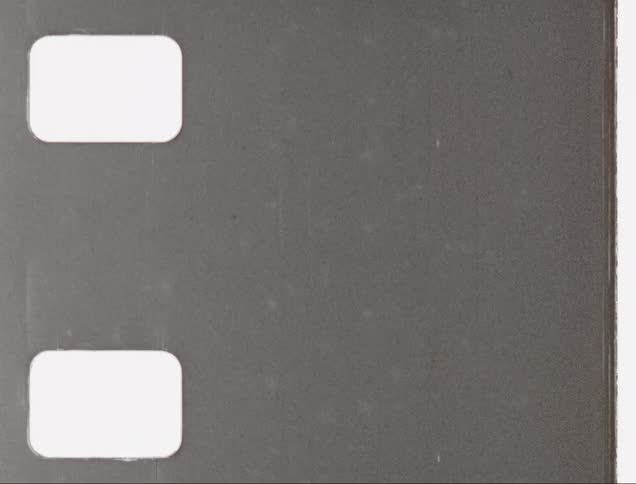 A piece of old film footage with significant deterioration scrolls by
