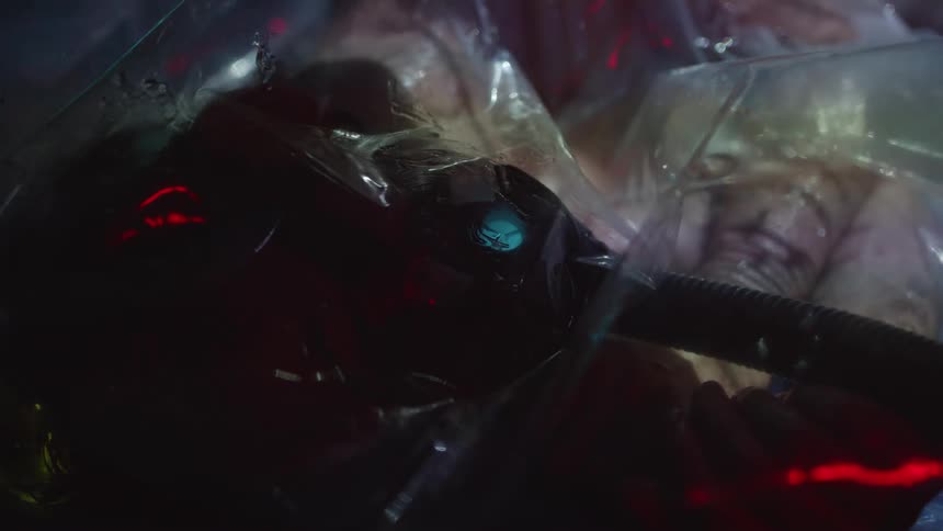 A man lies with a respirator on as lights flash