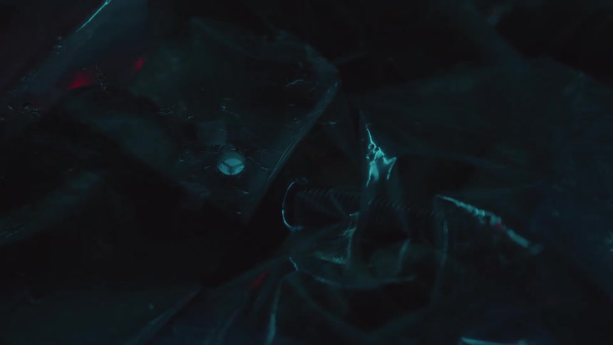 A flash of light illuminates machinery wrapped in a plastic bag