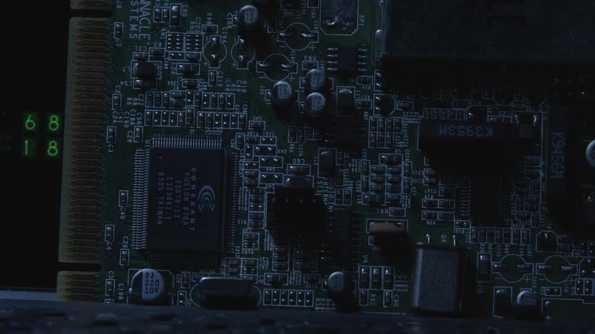 Electronic board next to a numeric display on a dimly lit room