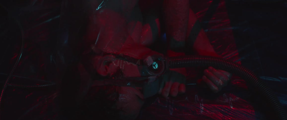 A man holds tubes with his hands as a mask covers his face