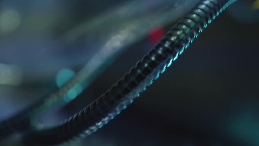 Metallic tubes and cables under clear plastic connected to futuristic machine