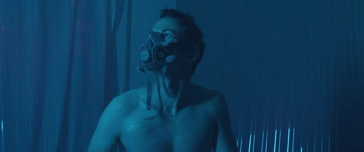 A white man wearing a face mask whips his head when a door opens into the room