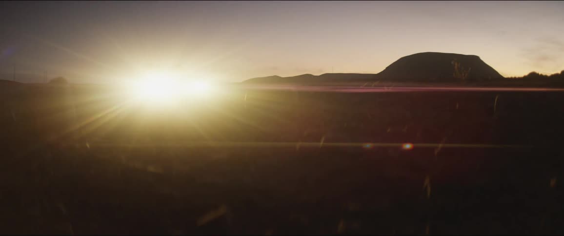 A car drives across through a countryside at night