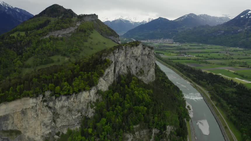 Fieldsparallel mountains and river leading toward town