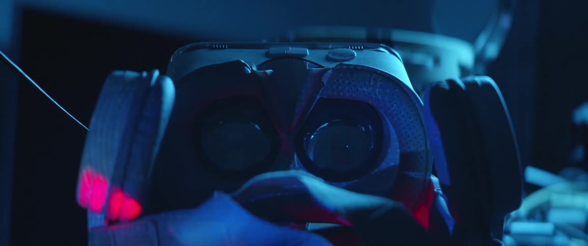 A high tech face mask sits on a table as light and symbols flash over it