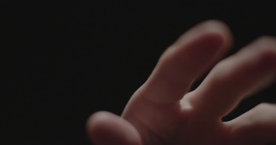 A hand is reaching toward the camera and moving out of focus