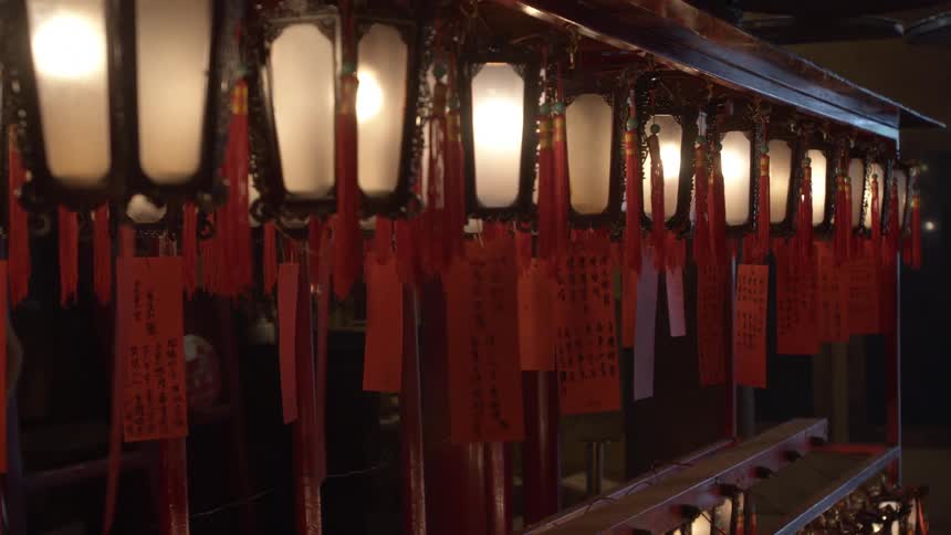 Rows of lanterns lit up with light bulbs tagged with signs on red paper