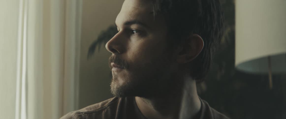 Man sitting on the sofa looks out the window