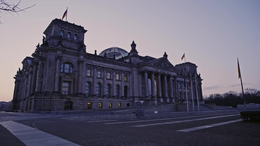 A government building with flags flying out front and on the roof