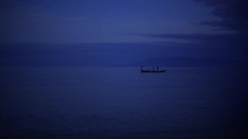 Two people stand on a boat with a flashing beacon