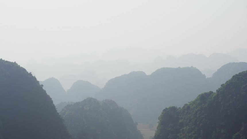 Fog hangs over a large mountain range