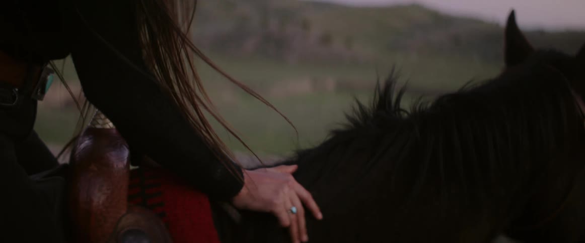 A woman is riding a horse outdoors