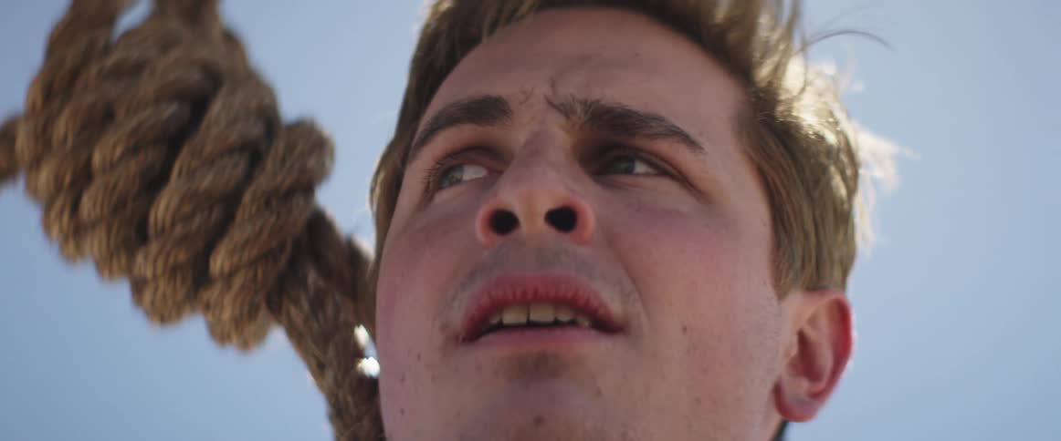 Man moves his head back and forth as he hangs in a noose
