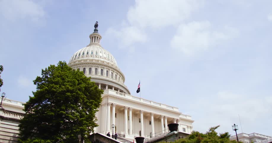 Two people stand on the steps in front of a government building