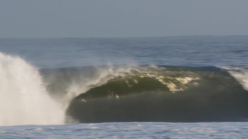 The surfer heads under the wave