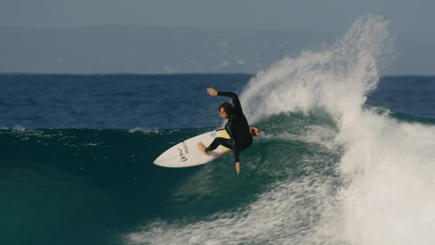 A young man surfs on large waves in the ocean