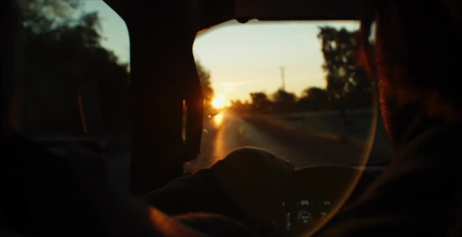 Man drives his car on the highway at sunset