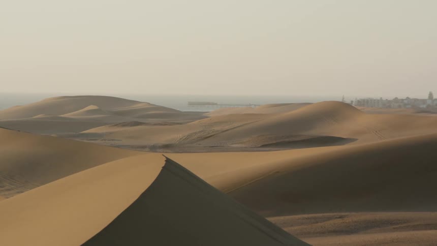 A town sits off in the distance in a desert region