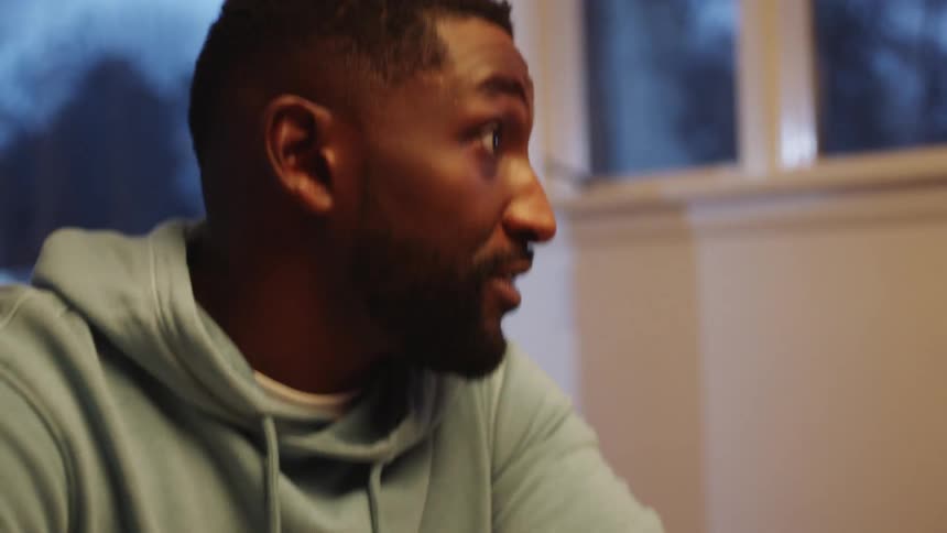 A black man laughs and talks