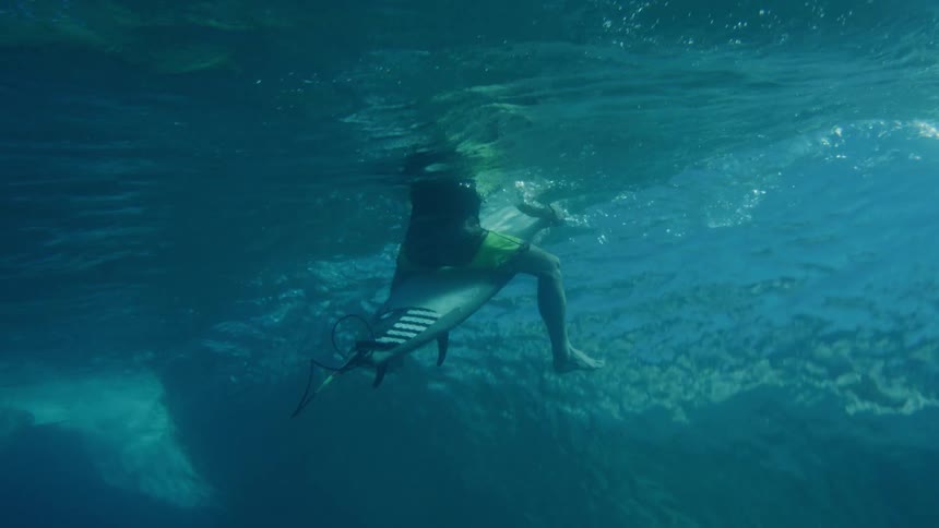 A surfer sits on a surfboard in the ocean