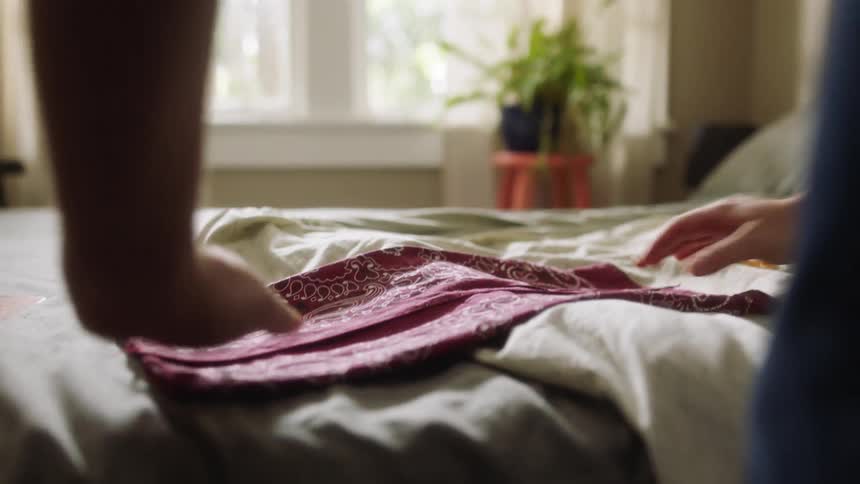 A person folds over a bandanna and press it flat
