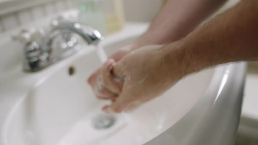 A person washes their hands in the bathroom
