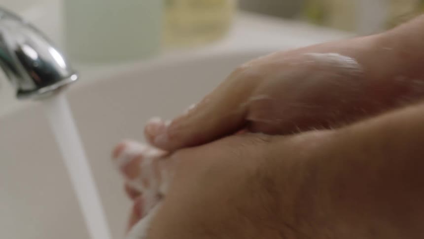 Man washes his hands with soap in the bathroom