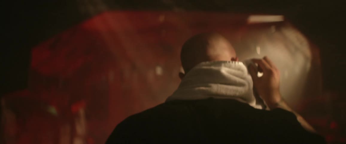 A man with a towel walking down a corridor