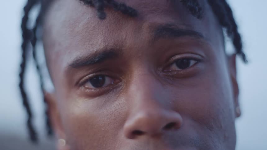 A sad black man closes his eyes and nods his head