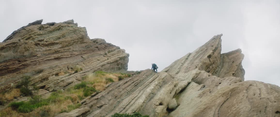 A man walks down a small cliff