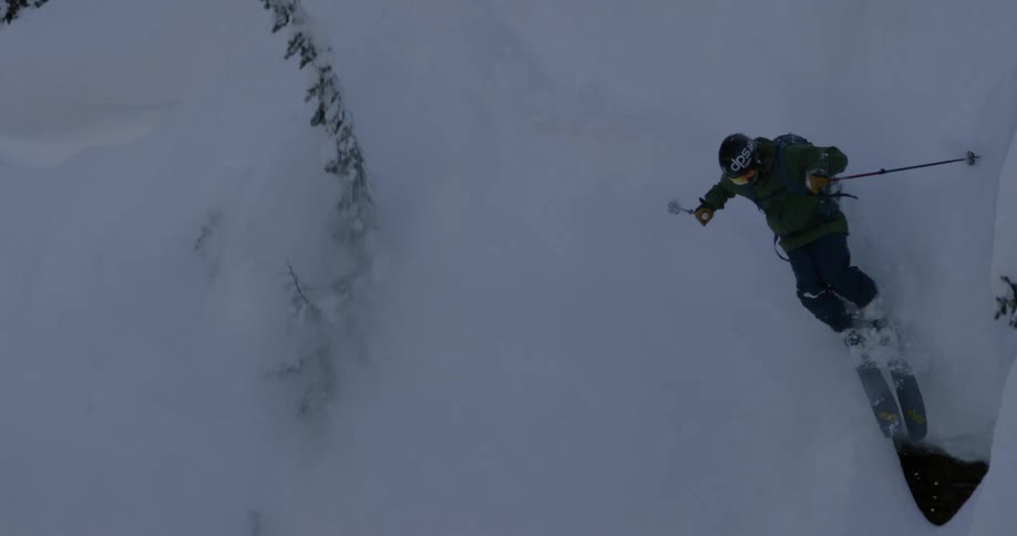 A man skiing down a steep snowy slope