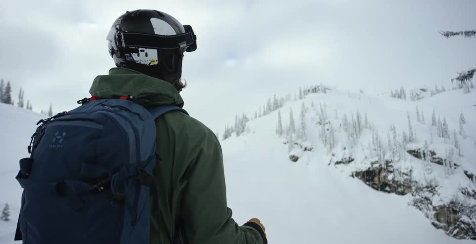 A skier stands on a snowy mountain