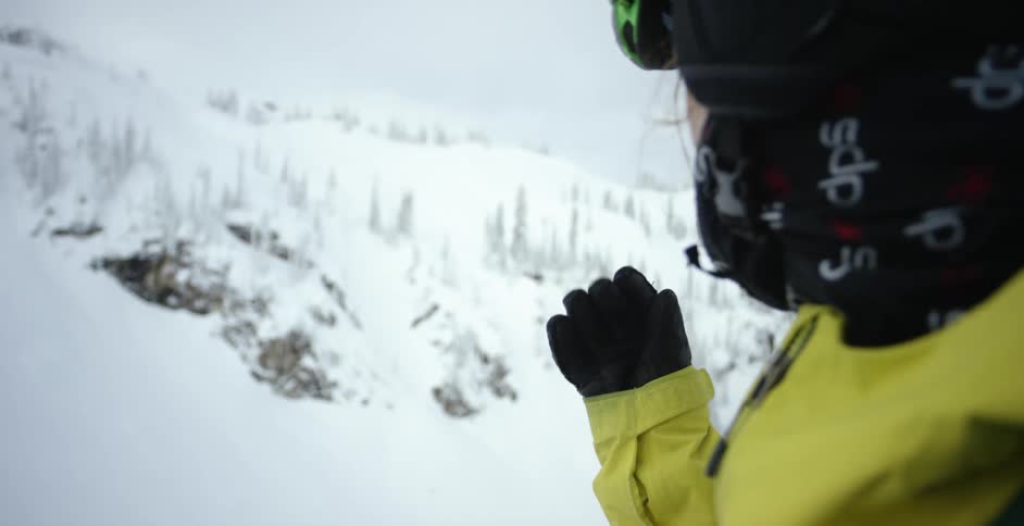 A skier adjusts their goggles on the slope