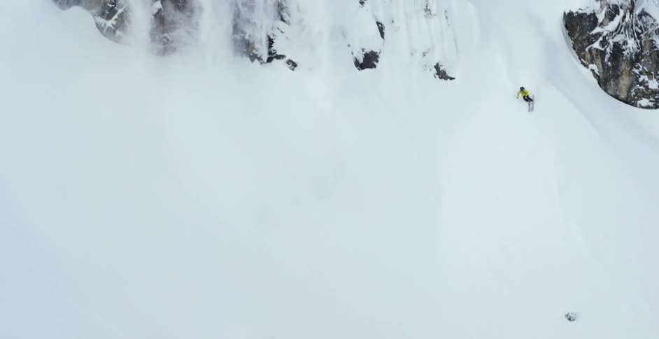 A person is skiing down over steep cliffs