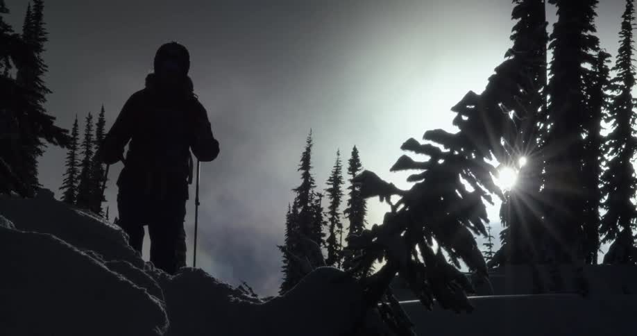 A person is climbing over the hill in silhouette