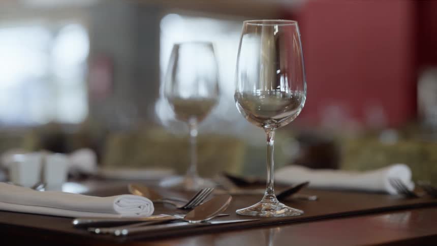 A table is set for dining with glasses napkins and utensils