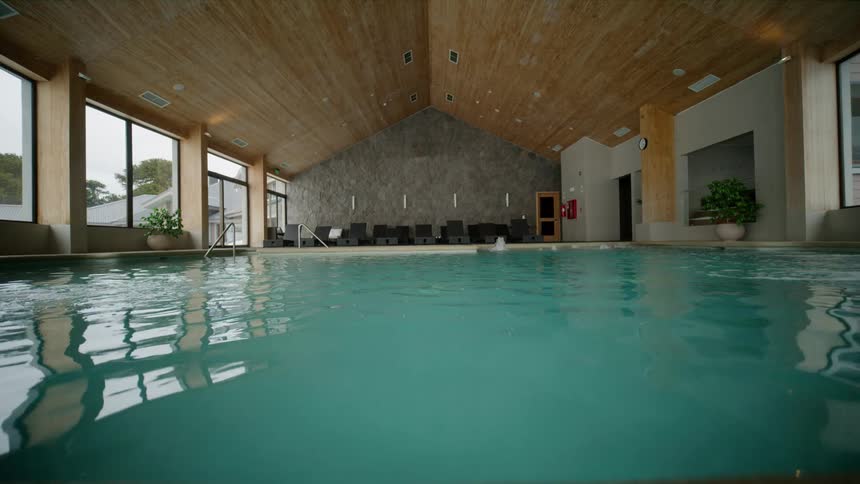 A resort features an indoor pool with turquoise water