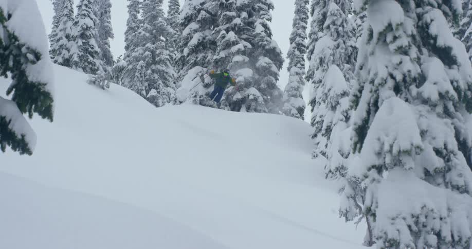 A man skis down a snow covered hill