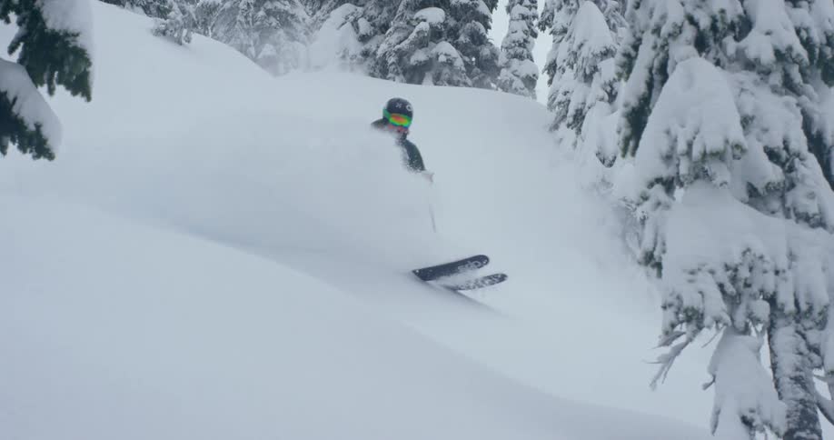Slow motion of downhill skier in powder