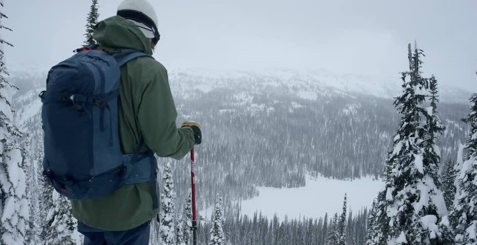 A man is looking at the horizon about to ski