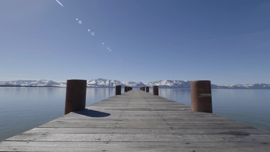 A dock extends into a mountain lake