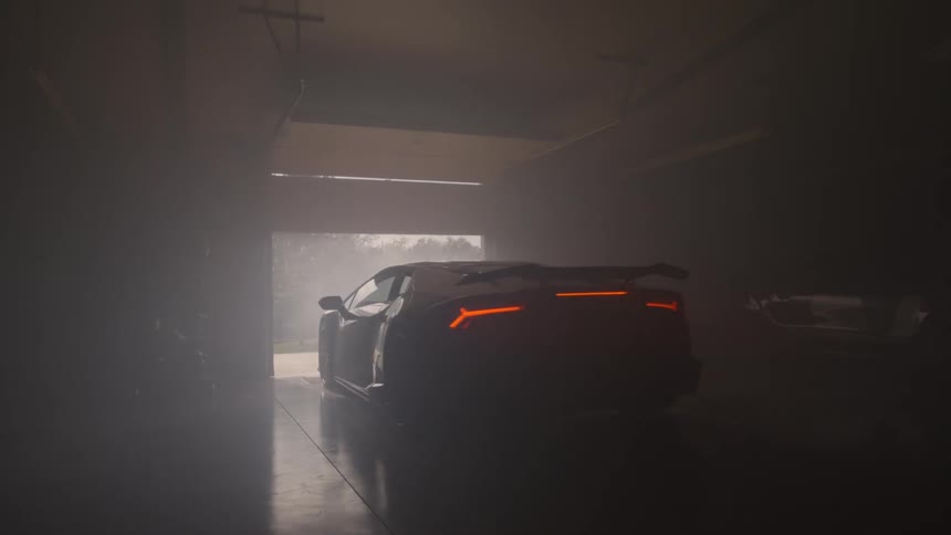 A garage door opening and a red sports car exiting the garage
