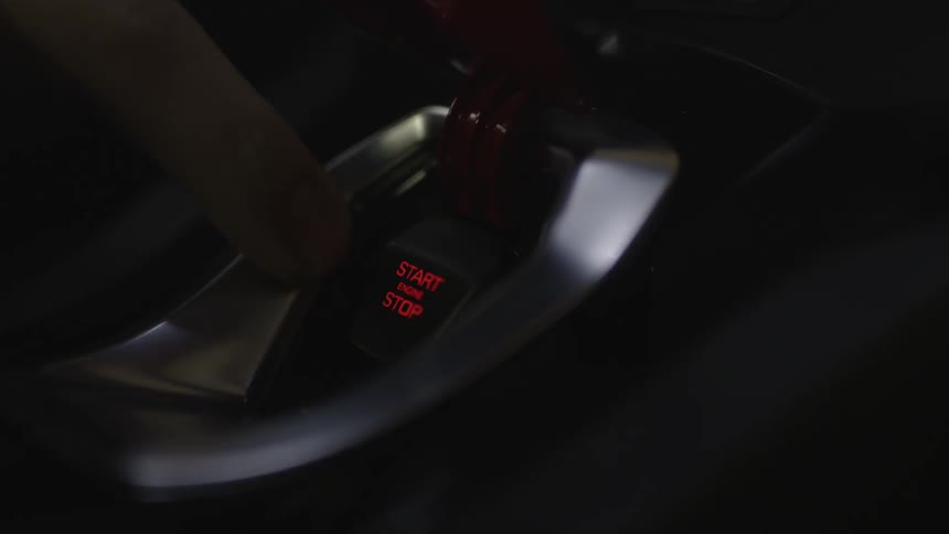 A finger pushes an ignition switch
