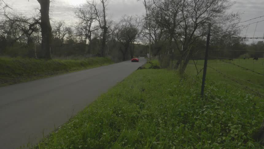 A car races down a country road
