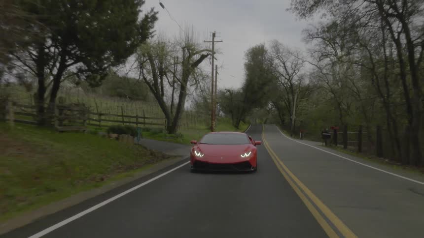 A sports car driving down a rural road