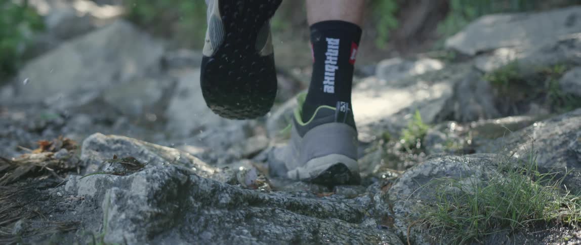 Close up of a hiker's feet walking in a rocky and wet area