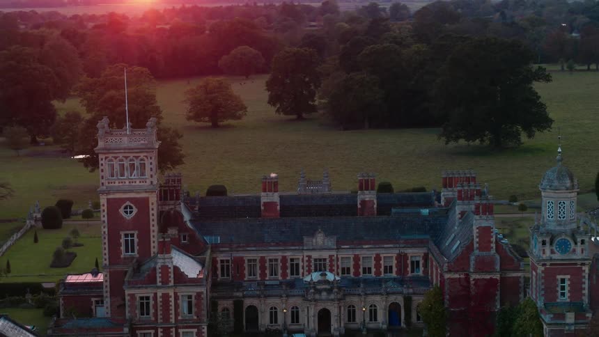 Cars parked at a church on a nicely manicured lawn as the sun sets