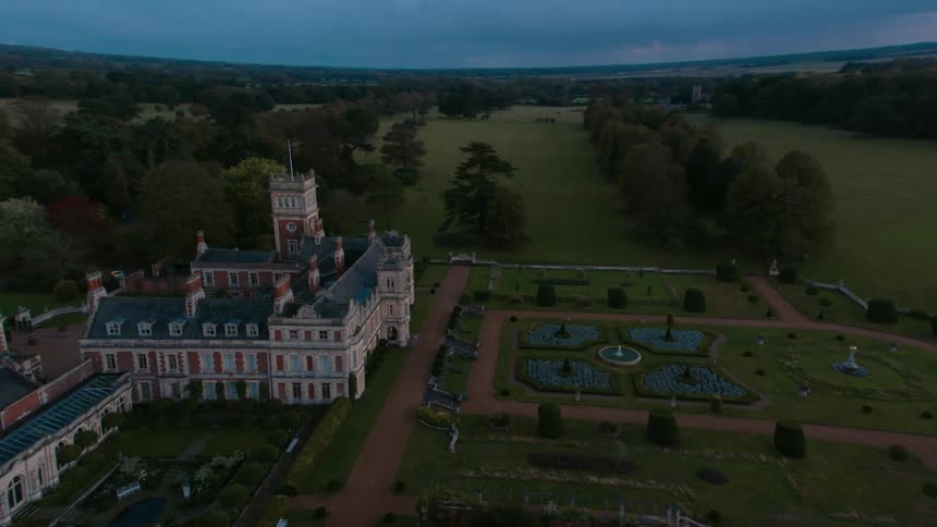 A garden sits adjacent to a large castle estate