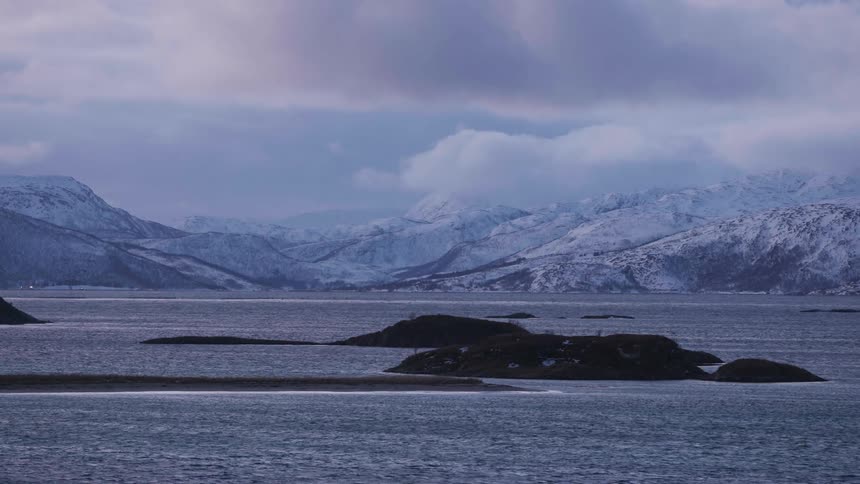 The water in front of snow covered mountains